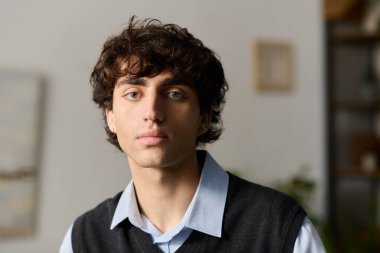 Kıvırcık saçlı genç bir adam şık dairesinde rahatlıyor, huzurun tadını çıkarıyor..