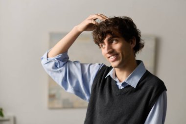 Kıvırcık saçlı yakışıklı genç adam çağdaş dairesinde bir anlık eğlencenin tadını çıkarıyor..