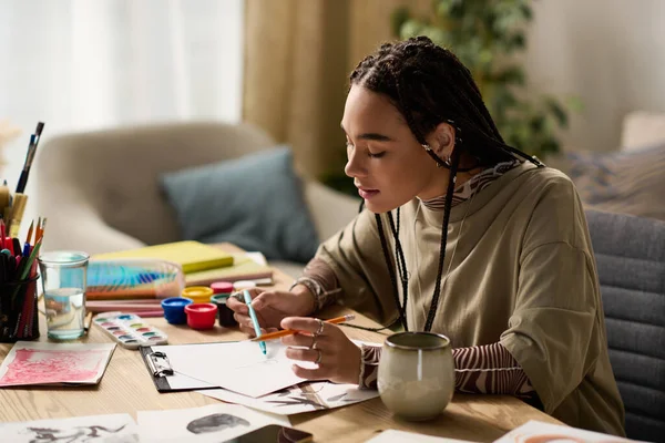 Örgülü odaklanmış genç bir kadın sanatsal yönünü modern ve şık bir evde keşfediyor..