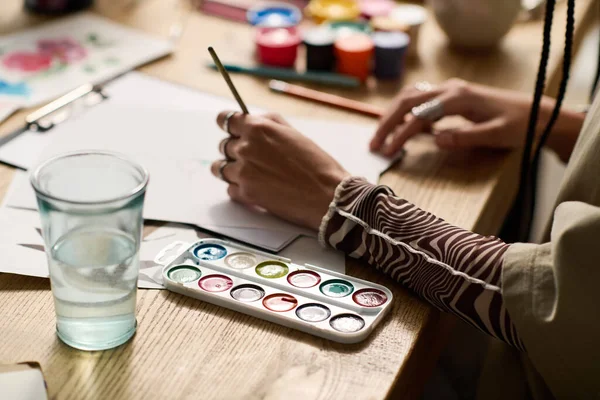 Genç bir kadın resim yaparken yaratıcılığını modern dairesinde gösteriyor..