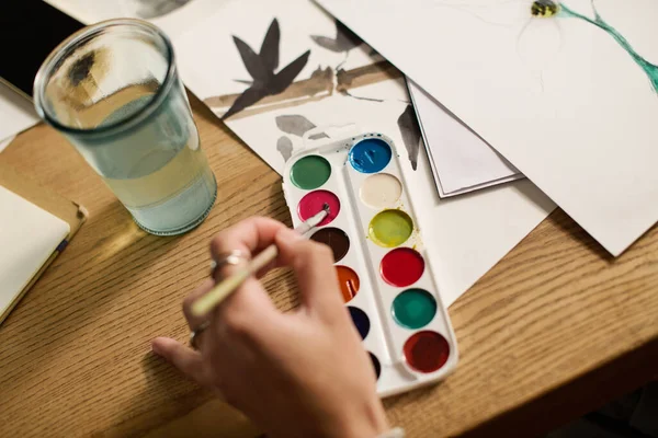 Genç bir kadın sanatsal esinlenerek modern dairesinde resim yapıyor..