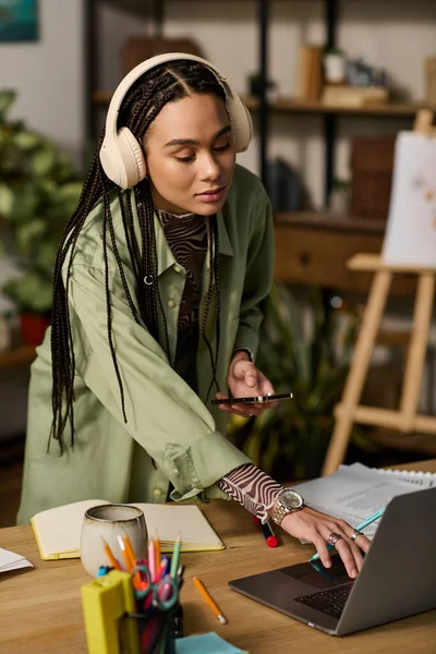 Örgülü genç bir Afrikalı Amerikalı kadın modern dairesinde bütün gün çok çalışıyor..