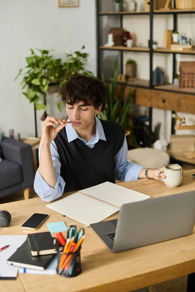 Genç adam son moda dairesinde düşünceli bir şekilde oturuyor, işini düşünürken kahvesini yudumluyor..