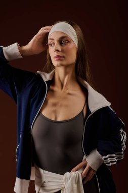 Şık bir sporcu kadın saç bandıyla şık bir spor kıyafetiyle rahatça poz veriyor..