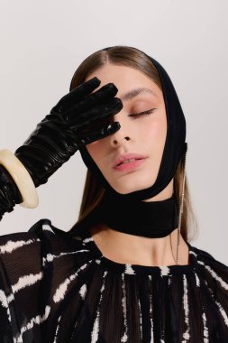 Güzel bir kadın zarif kıyafetler ve şık bir saç bandı takarak zarif bir moda sergiliyor..