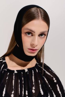 Kendine güvenen genç bir kadın zarif bir şekilde poz verir..