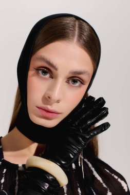 Zarif genç bir kadın zarif bir şekilde poz veriyor, eşsiz moda anlayışını sergiliyor..