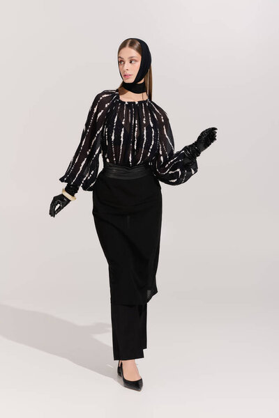 A beautiful young woman poses confidently in elegant attire, highlighting her stylish headband.