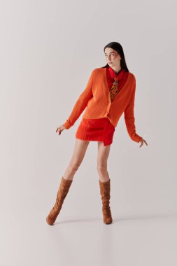 Modern bir stüdyoda, güzel bir kadın kendine güveni ve yeteneği olan modaya uygun bir kıyafet modeller..