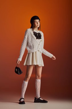 Güzel bir kadın kendine güveni tam, modern tarzı ve zarafeti somutlaştıran şık bir elbisenin içinde duruyor..