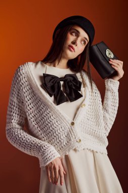 Zarif bir kadın şık örgü kıyafetlerini ve göz alıcı aksesuarlarını sergiliyor..