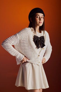 Tarz sahibi genç bir kadın hoş bir elbise ve rahat bir hırkayla kendine güven yayar..