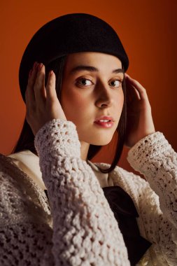 Genç bir kadın şık bir kıyafet giyer. Zarafeti sıcak ve davetkar bir ortama özgüvenle kucaklar..