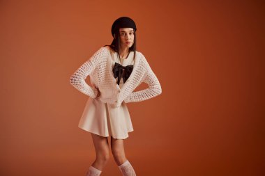 Şık bir kadın yaratıcı bir mekanda modern zarafet ve cazibe yayarak kendine güvenerek poz verir..