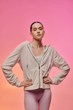 Güzel bir kadın moda anlayışını, yumuşak pembe renkler içinde, rahat bir kıyafetle sergiliyor..