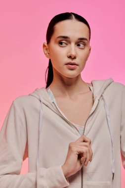 Zarif genç kadın renkli bir ortamda çağdaş bir moda sergiliyor.