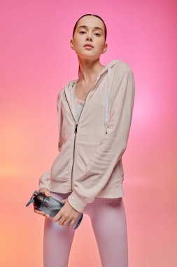 Genç bir kadın şık bir şekilde spor salonunda kendine güvenini ve tarzını sergiliyor..