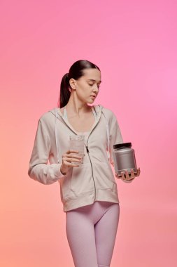 Şık bir genç kadın elinde su bardağı ve kabıyla zindeliğiyle hava atıyor..