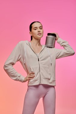 Genç bir kadın, elinde spor konteynırıyla moda anlayışını sergiliyor..