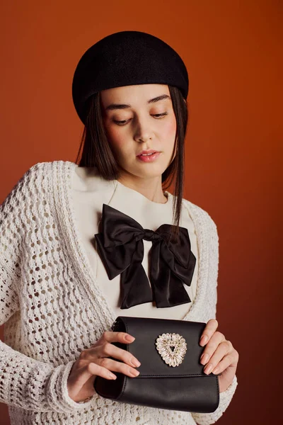 Şık bir elbise ve şık aksesuarlarla gösteriş yapan şık genç bir kadın..