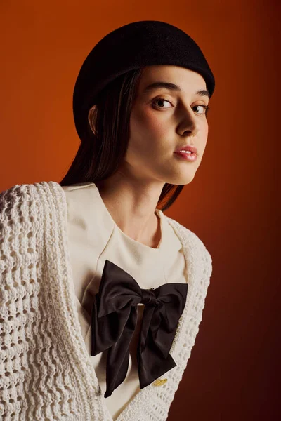 Şık giyinmiş genç bir kadın kapalı bir ortamda kendine güveni tam..