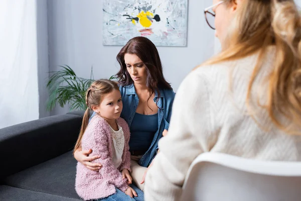 Madre preocupada abrazando a su hija mientras visita al psicólogo — Stock Photo