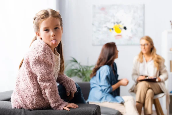 Figlia scherzare mentre la madre parla con lo psicologo — Foto stock