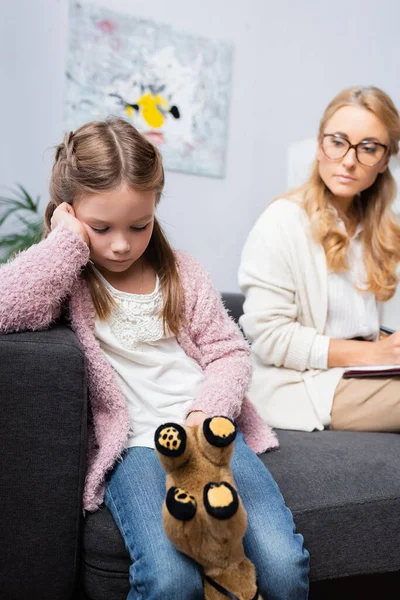 Chateado menina paciente com brinquedo visitando psicólogo — Fotografia de Stock