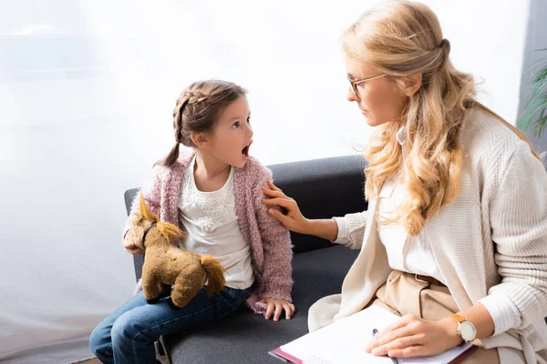 Kleines Mädchen mit Spielzeug schreit beim Psychologen-Besuch — Stockfoto