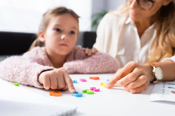 Paciente niña calculando con cifras mientras visita a psicólogo - foto de stock