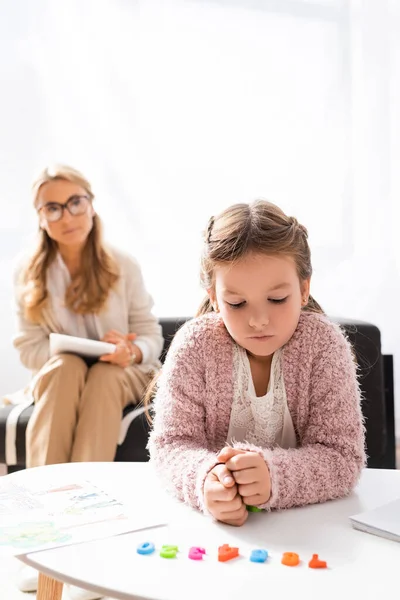 Fille patient calcul avec des chiffres tout en visitant psychologue — Photo de stock