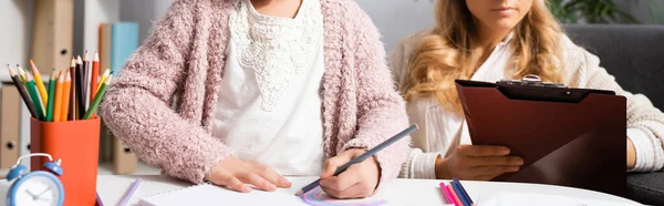 Vista ritagliata di bambina disegno immagini con matite colorate durante la visita psicologo — Foto stock