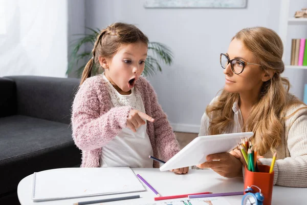 Geschocktes Kind zeigt beim Psychologen-Besuch auf digitales Tablet — Stockfoto