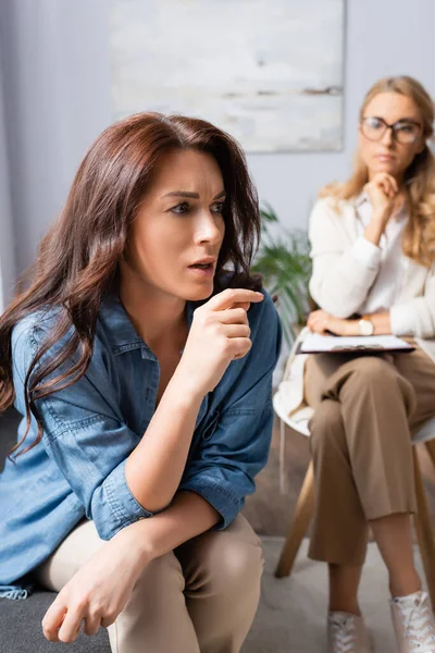 Triste femme brune avec des problèmes mentaux raconter l'histoire au thérapeute — Photo de stock