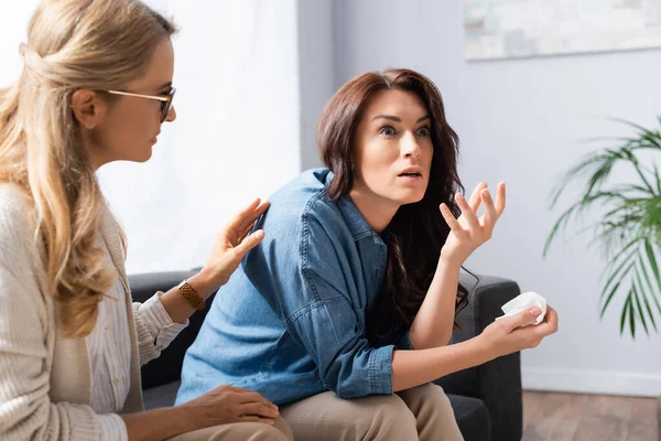 Blonde Therapeutin beruhigt Patientin während der Behandlung — Stockfoto