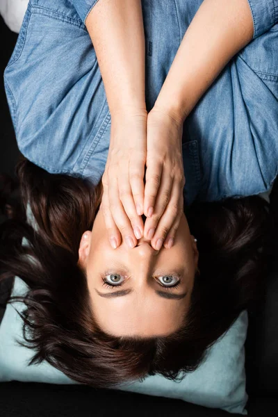 Top view of terrified brunette woman covering mouth — Stock Photo