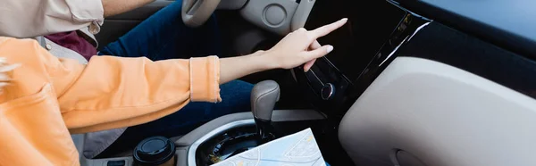 Vista recortada de la mujer con el mapa utilizando el sistema de audio en el coche cerca del marido, pancarta - foto de stock