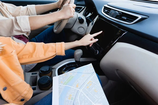 Vista recortada de la mujer con el mapa usando el sistema de audio mientras el marido conduce el coche - foto de stock