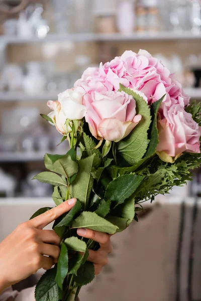 Close up de buquê com hortênsias floridas e rosas em mãos de florista feminino no fundo borrado — Fotografia de Stock