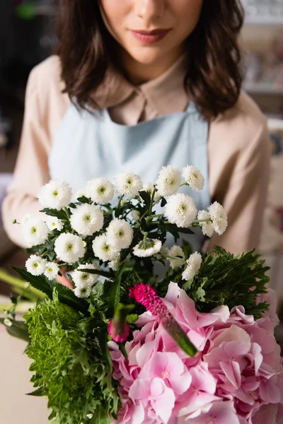 Close up view of bouquet with hydrangea, celosia and chrysanthemums with blurred female florist on background — Stock Photo
