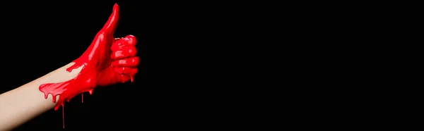 Vista ritagliata di dipinto a mano in vernice rossa mostrando pollice in su isolato su nero, banner — Foto stock