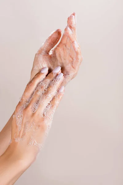 Vista recortada de la mujer lavándose las manos aisladas en gris - foto de stock