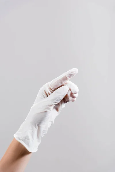 Vista recortada de la mano en guante de látex aislado en gris - foto de stock