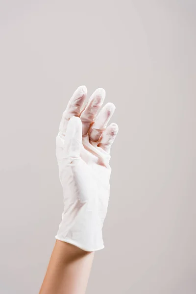 Обрезанный вид руки в латексной перчатке, изолированный на сером — стоковое фото