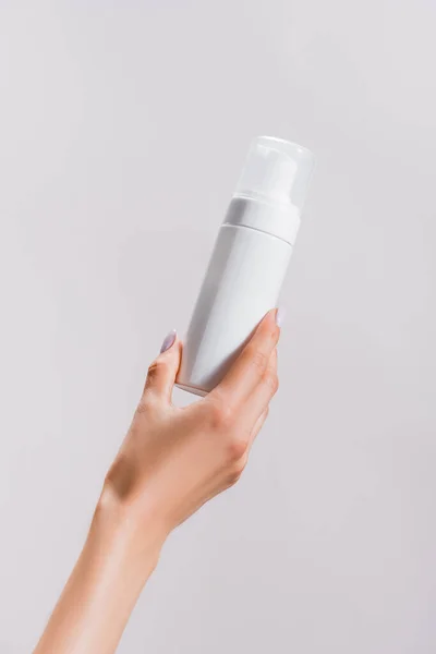 Cropped view of woman holding cleansing foam isolated on grey — Stock Photo