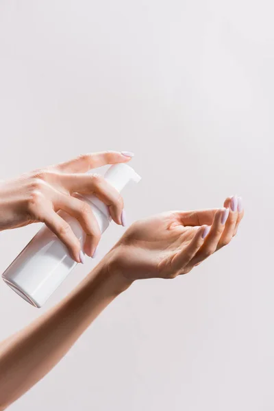 Vista recortada de la mujer aplicando espuma limpiadora aislada en gris - foto de stock