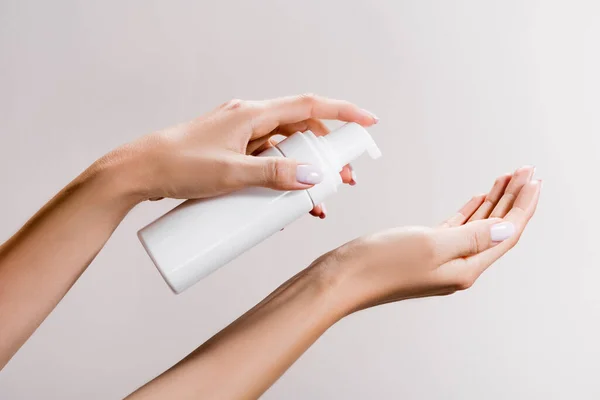 Vista ritagliata della donna che applica schiuma detergente isolata sul grigio — Foto stock