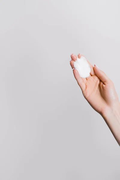 Vista recortada de la mujer con crema de manos aislado en gris - foto de stock