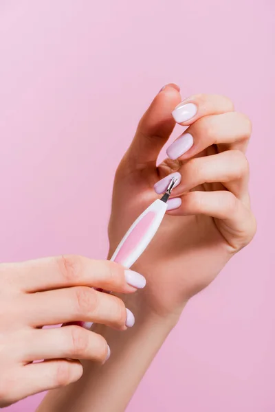 Cropped view of woman using cuticle clipper isolated on pink — Stock Photo