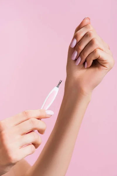Cropped view of woman using cuticle clipper isolated on pink — Stock Photo